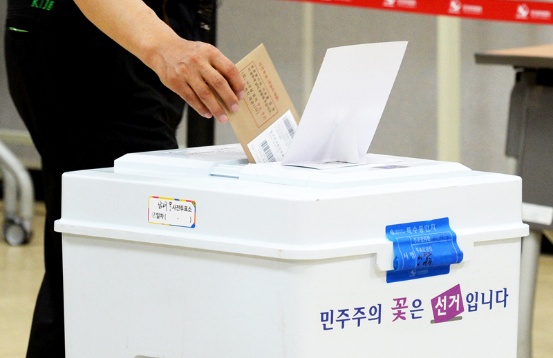 ▲ 6·13 지방선거 사전투표 둘째날인 9일 오후 남해군 남해읍 화전도서관 투표소에서 한 유권자가 투표용지가 담기 봉투를 투표함에 넣고 있다. 