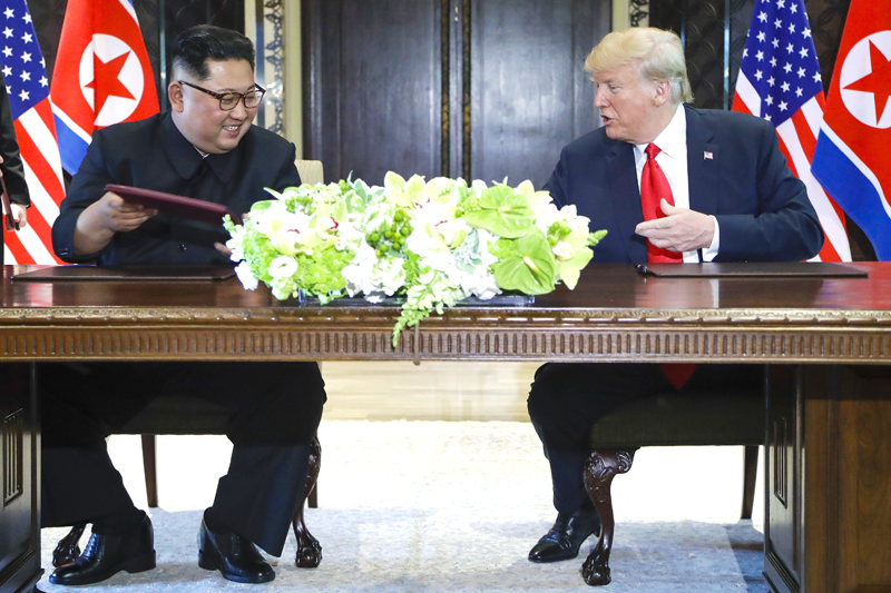 ▲ 도널드 트럼프 미국 대통령과 김정은 북한 국무위원장이 12일 싱가포르 센토사 섬 내 카펠라 호텔에서 합의문에 서명한 후 웃고 있다.