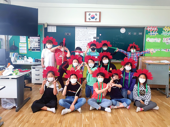 ▲ 지난 14일 아침 함안 아라초등학교 아이들이 카네이션 머리띠를 쓰고 기념사진을 촬영하고 있다.