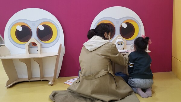 장유도서관을 찾은 한 어린이가 어머니와 함께 책 읽어주는 로봇 ‘루카’를 이용하고 있다.