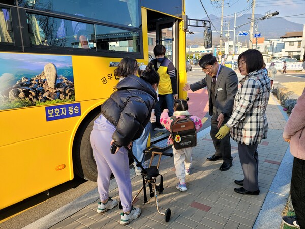 산청교육지원청 관계자가 어린이 통학차량 교통 현장에서 학부모와 함께 어린이의 승하차를 돕고 있다.