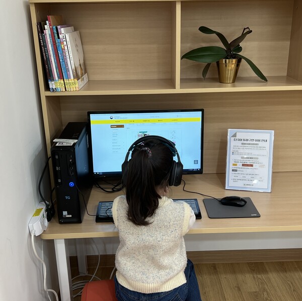 도서관을 찾은 한 어린이가 다국어 동화구연 서비스를 이용하고 있다.